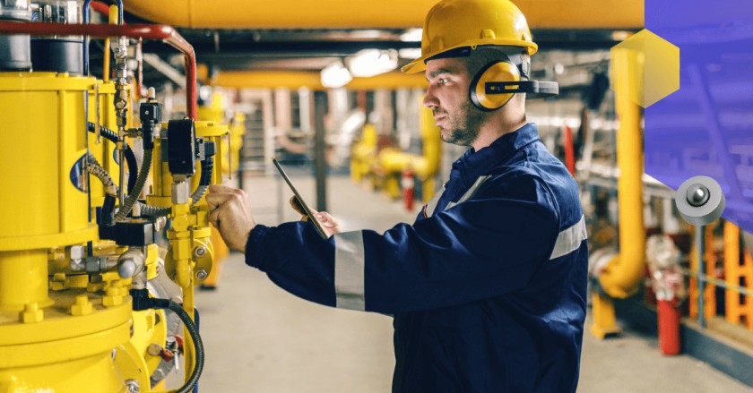 Worker in a safety vest and a hard hat checking equipment
